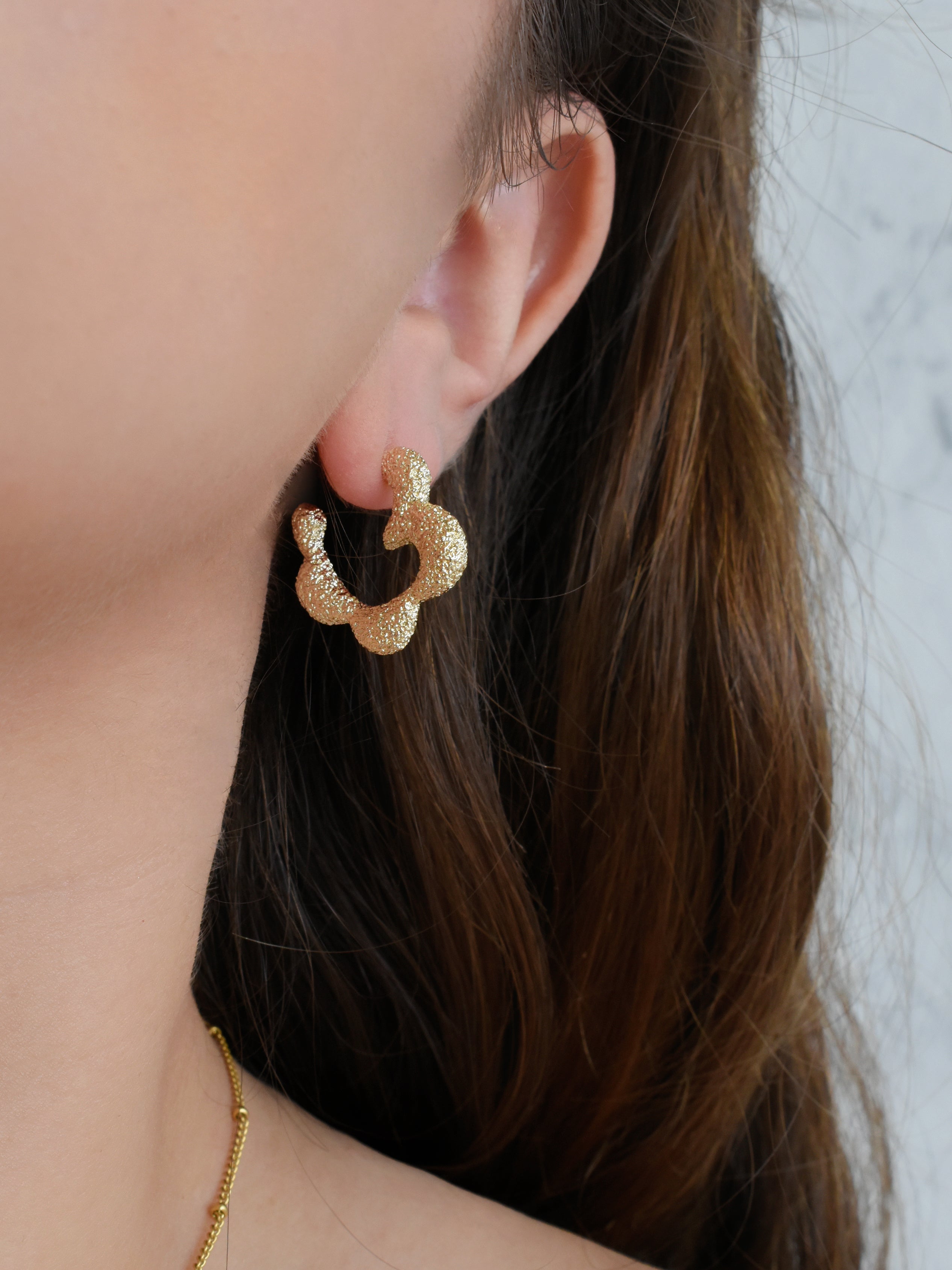 Arete media flor silueta dorada