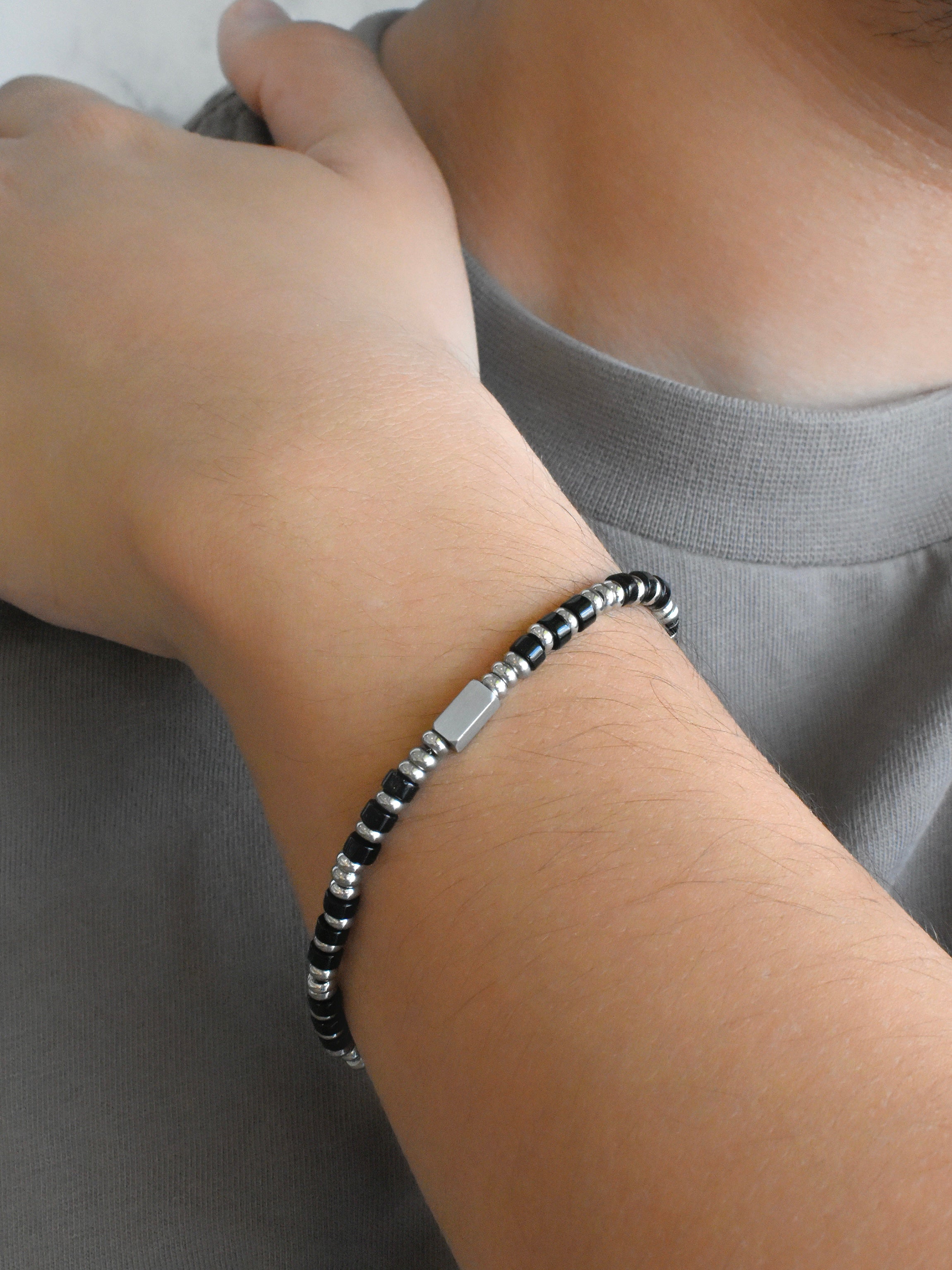 Pulsera bolitas negras y placa